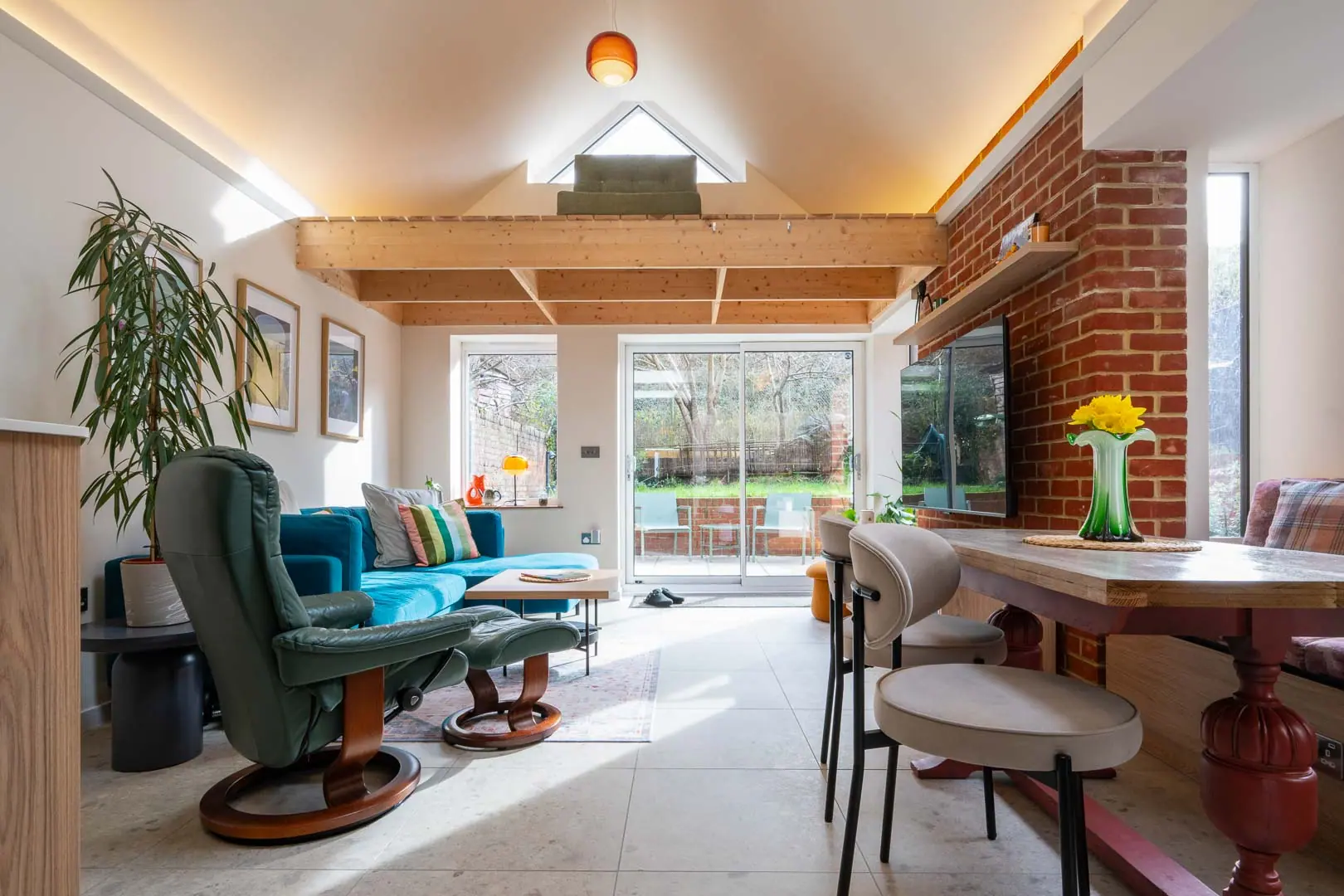 The open plan runs from the seating area through to a dining table set into the side bay.