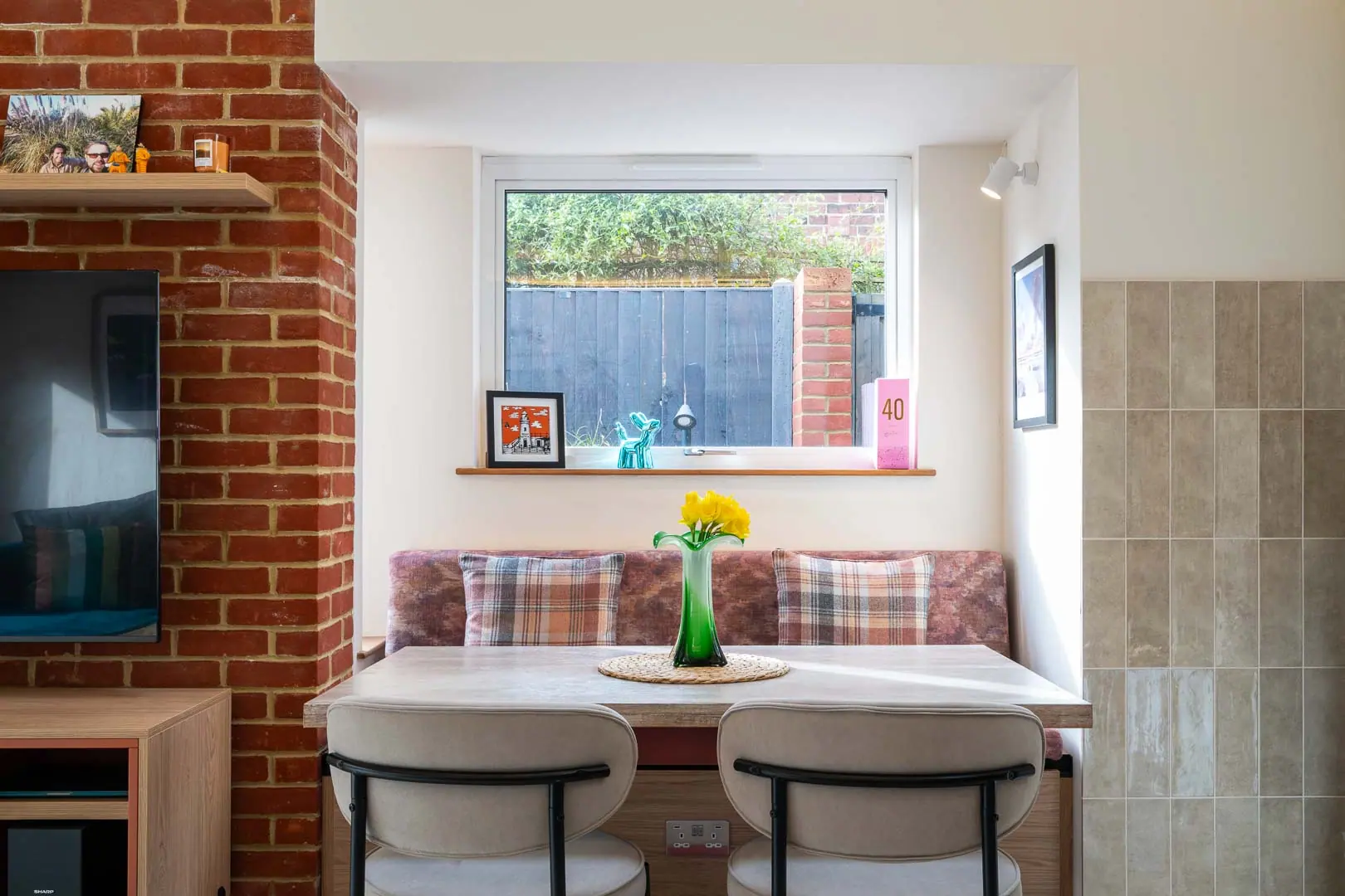 The dining area sits in one of two side bays, added sideways so the garden stays intact.